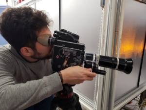 Columbia University PhD student Niccolò Bigagli holding a 16mm camera in Sebastian Will’s lab.