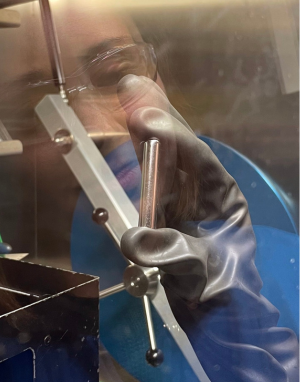 Victoria Posey holding a niobium ampule inside the glovebox. 