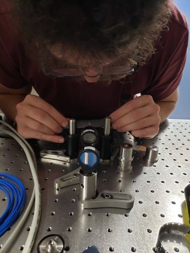 Columbia University PhD student Niccolo Bigagli adjusting an optical lens Niccolo Bigagli adjusting an optical lens